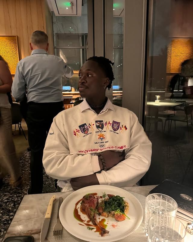 Portrait of Chef Sage Udofia at a restaurant table with a plated dish.