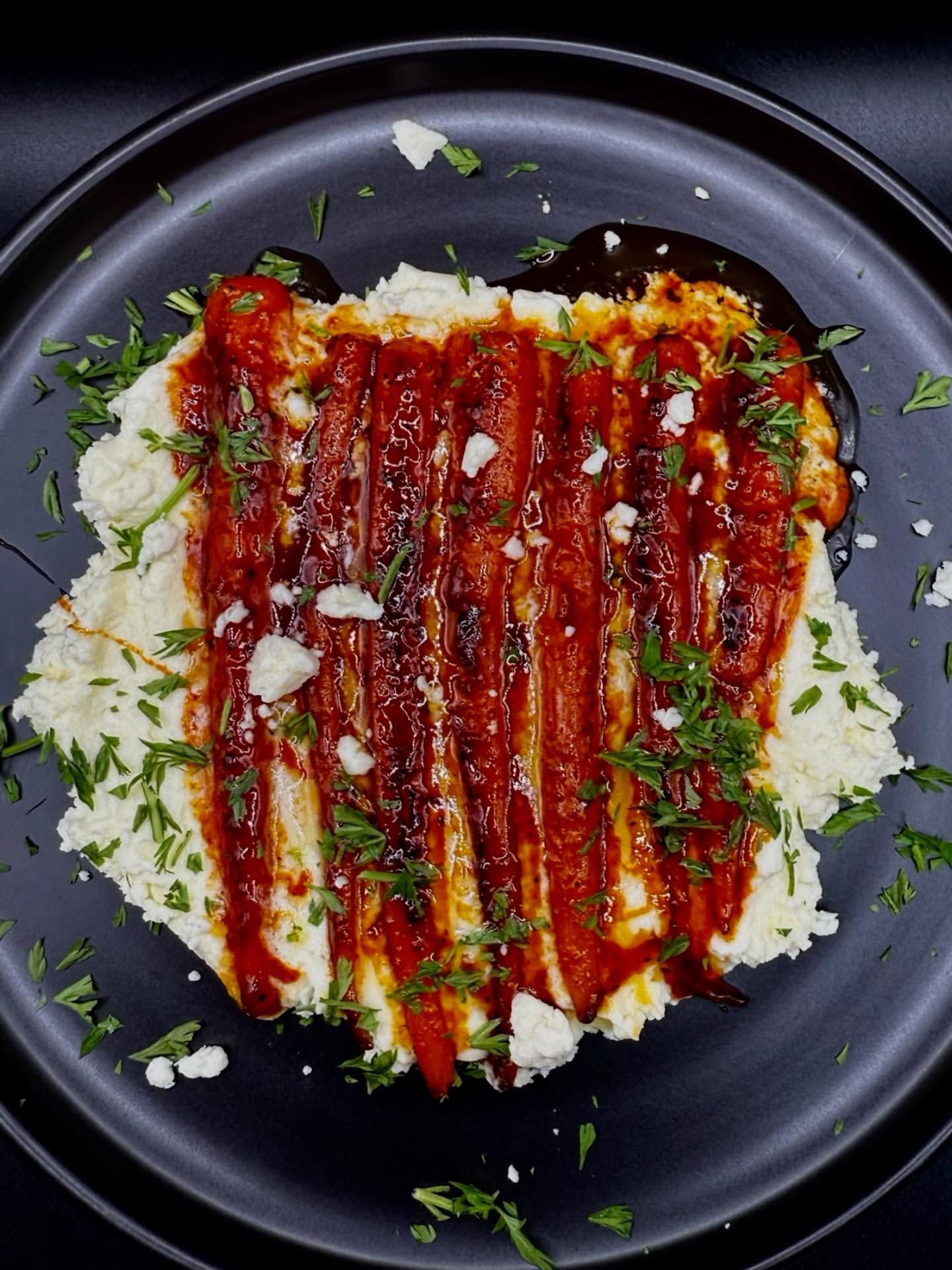 Charred eggplant with a tomato sauce over creamy base.